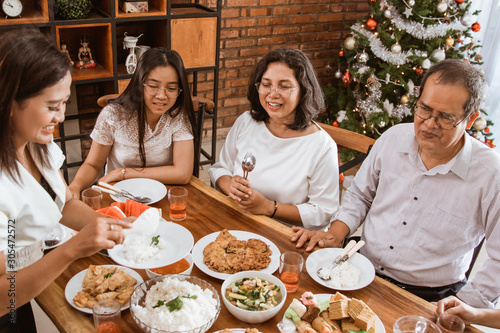 happy asian family tradition having lunch together on christmas day at home