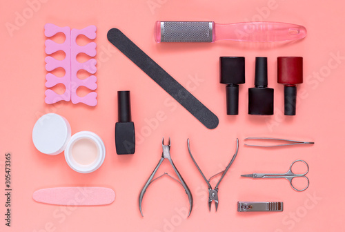 Set of cosmetic tools. Manicure and pedicure equipment on pink background. Instrument for nail salon: gel polishes, nail files, clippers. Top view.