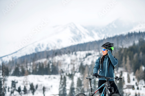 Female mountain biker standing outdoors in winter nature.