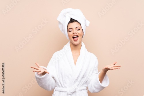 Teenager girl in a bathrobe over isolated background unhappy and frustrated with something