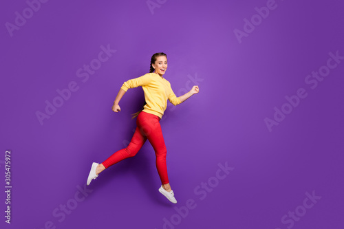 Full body profile photo of millennial lady jumping high rushing sale shopping speed running race wear casual yellow pullover red trousers isolated purple color background