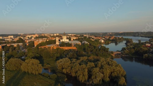 Beautiful picturesque river city landscape with Medieval Catholic ancient castle-fortress. Monastery of the Barefoot Carmelites. Aerial survey-flight of drone photo