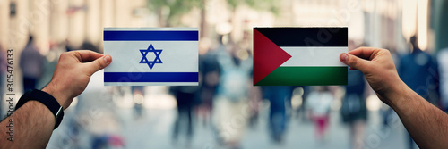 Photography Hands holding Palestine vs Israel flags as dispute on politics, culture, religion and territory