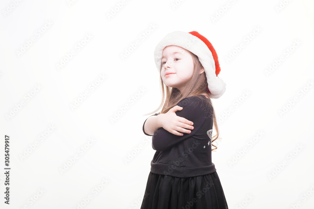 Happy girl in santa hat on white background. Funny young child waiting for christmas, new year and presents. holiday, sale concept with place for text Happy girl in santa hat on white background. Funny young child waiting for christmas, new year and presents. holiday, sale concept with place for text