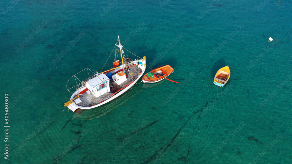 Aerial drone photo of traditional wooden fishing boat in old port of Mykonos island,  Cyclades, Greece