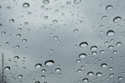 Rain drops on window glasses surface with cloudy background