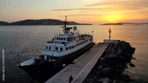 Quadro su tela Aerial drone photo of yacht docked in old port of Mykonos island at sunset, Cycl
