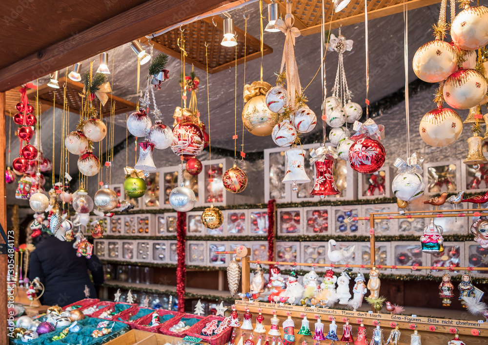 Naklejka premium Christmas tree decorations for sale in Berlin Christmas market. Stalls with crafts souvenirs, decorations and holiday attributes on the Bazaar.