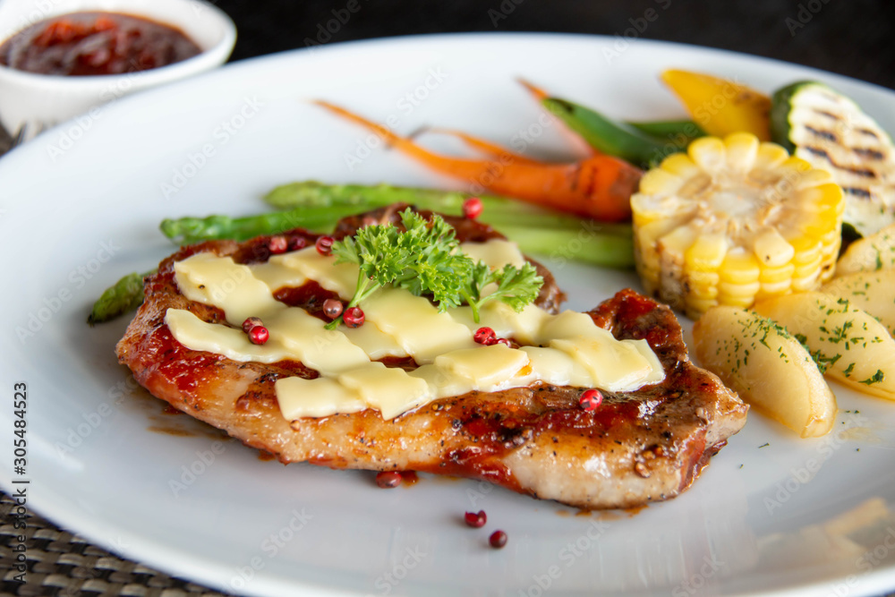  pork steak cheese on top in white plate