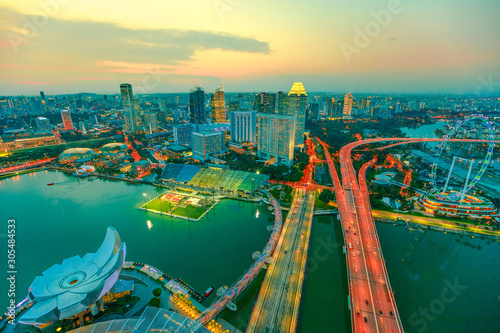 Canvas Print Wide panorama at sunset and blue hour of Singapore Marina Bay with illuminated skyscrapers of the financial district in the downtown of the city