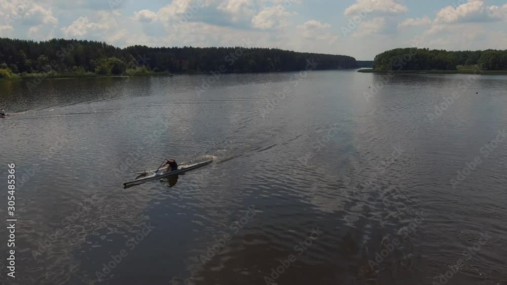 Canoeing competition-rowing boating sport. Athletes men rowers on outrigger canoe boats with stabilizer in the river water area. Aerial survey Canoeing competition-rowing boating sport. Athletes men rowers on outrigger canoe boats with stabilizer in the river water area. Aerial survey