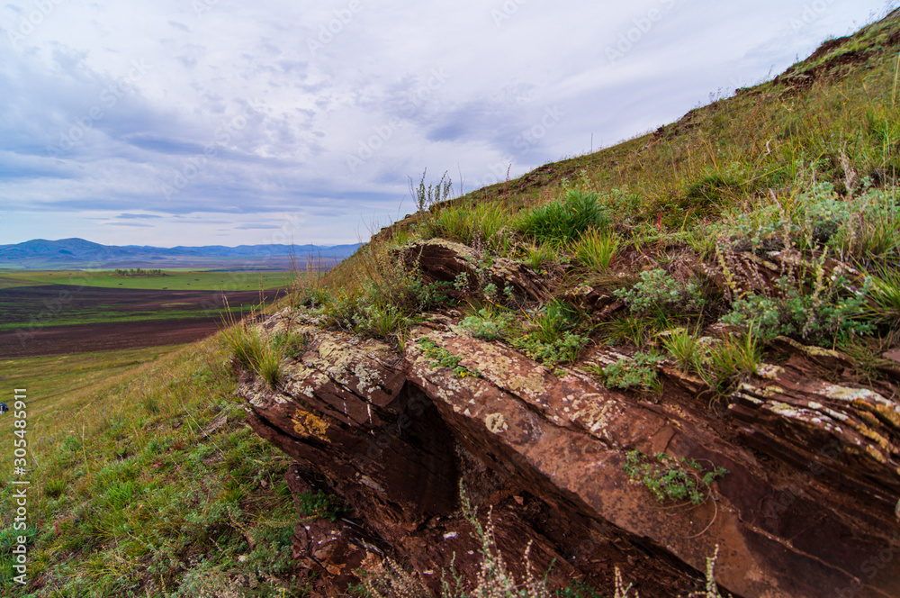 Fototapeta premium Granite rocks. Fields. Sky. The clouds.