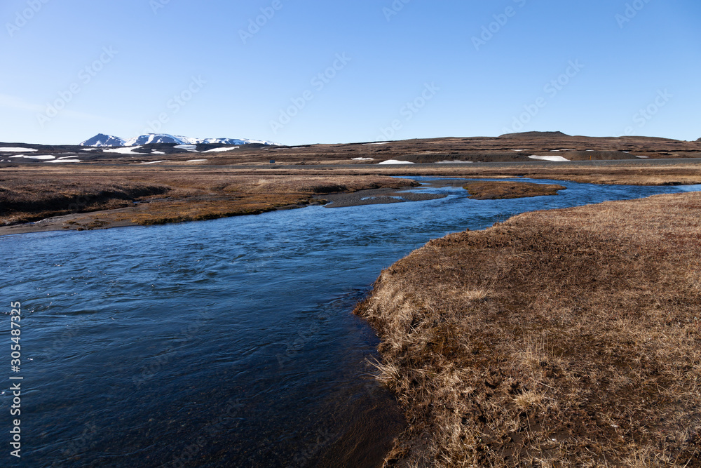 Stormy river on a stony rocky calm deserted spring landscape of Iceland