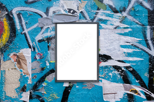 Blank notice advertising board for mockup on rough urban poster painted graffiti covered wall