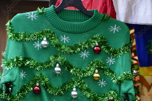 Beautiful or ugly: green Christmas sweater with decor balls Fototapeta