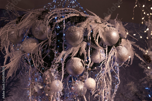 Christmas balls silver, snowy branch and light garland 