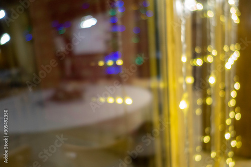 Merry Christmas and New Year holidays background. Blurred bokeh lights near the window.