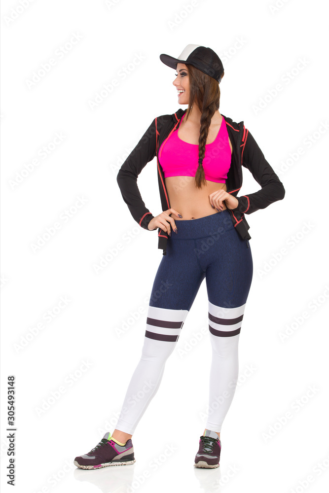 Young Fitness Woman Is Standing With Hands On Hip And Looking Away Young Fitness Woman Is Standing With Hands On Hip And Looking Away