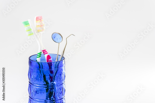 Toothbrushes in a glass and dental care set isolated on white background.