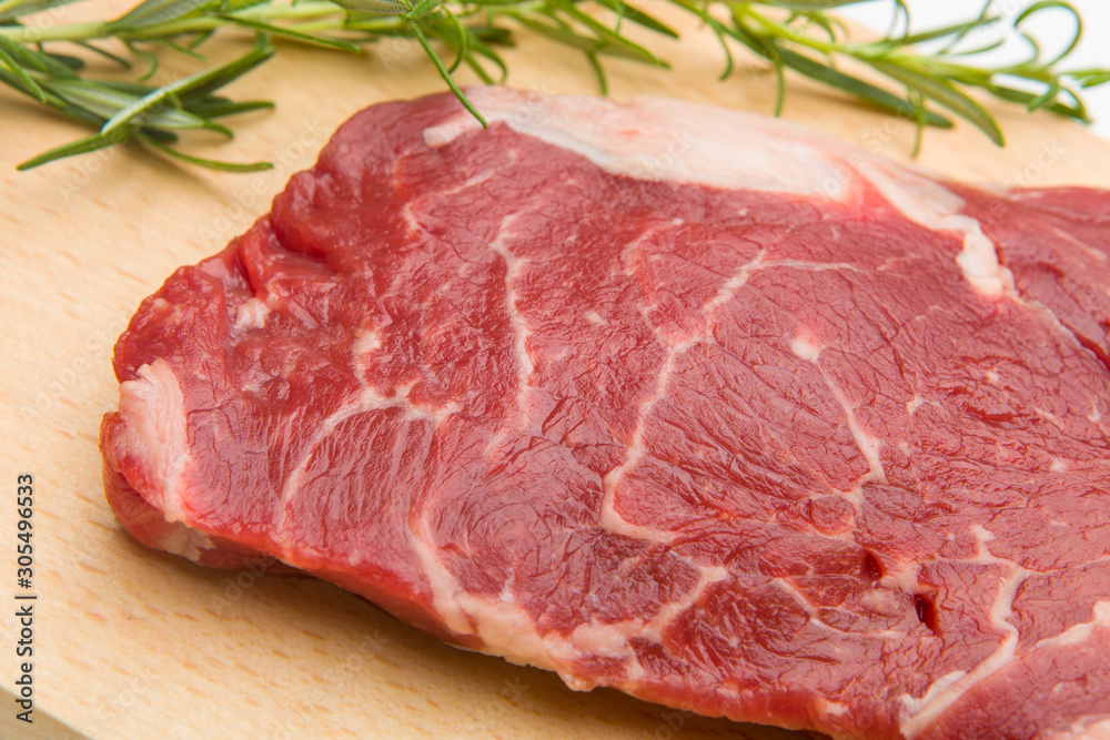 Raw seasoned beef slice on a wooden board Raw seasoned beef slice on a wooden board