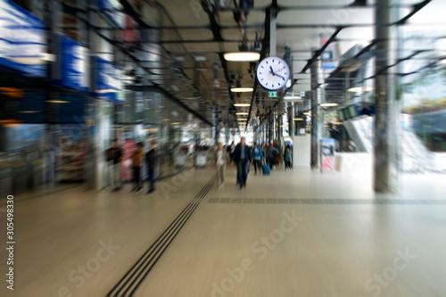 Blurry motion image of people walking at the main train station called Amsterdam Centraal. A major international railway hub  it is used by 162 000 passengers a day. Transportation concept.
