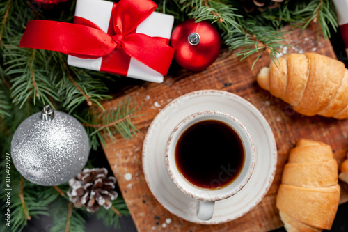 Christmas coffee and croissants with Christmas tree and gifts, toys on a stone background