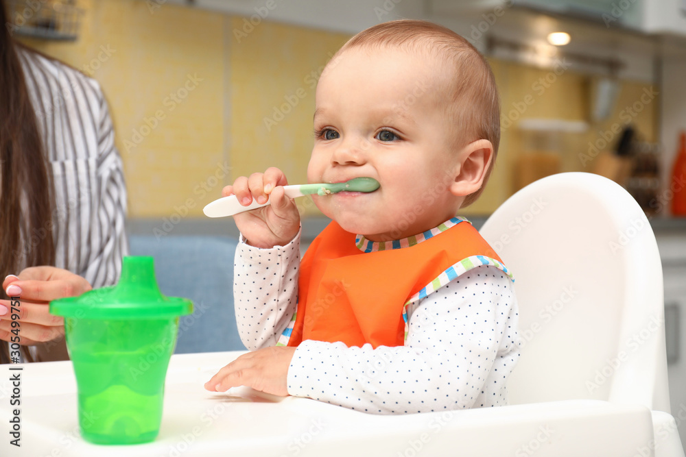 Young mother feeding her little baby at home Young mother feeding her little baby at home