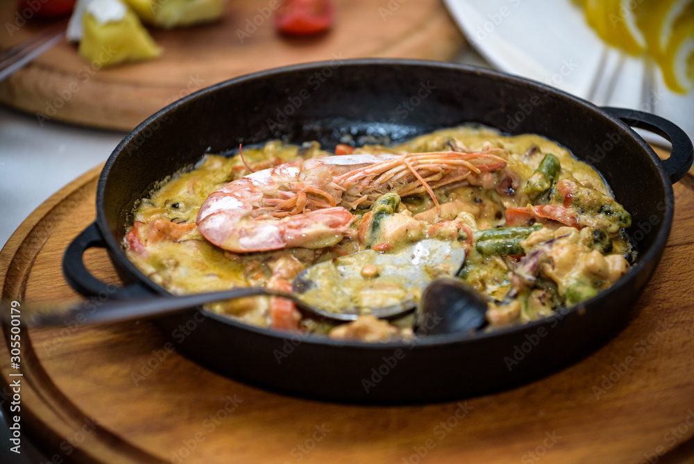 Shrimps roasted on frying pan with onion, garlic and chili on wooden background. Top view Shrimps roasted on frying pan with onion, garlic and chili on wooden background. Top view