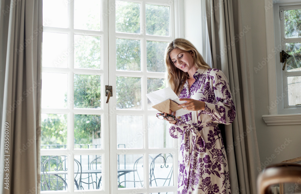 Woman reading letter at the window Woman reading letter at the window