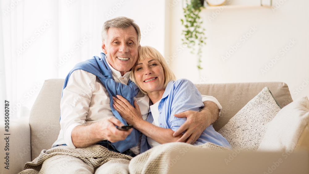 Elderly spouses watching television, man choosing channel