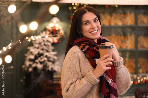 Beautiful woman with cup of coffee in decorated cafe. Christmas celebration © New Africa