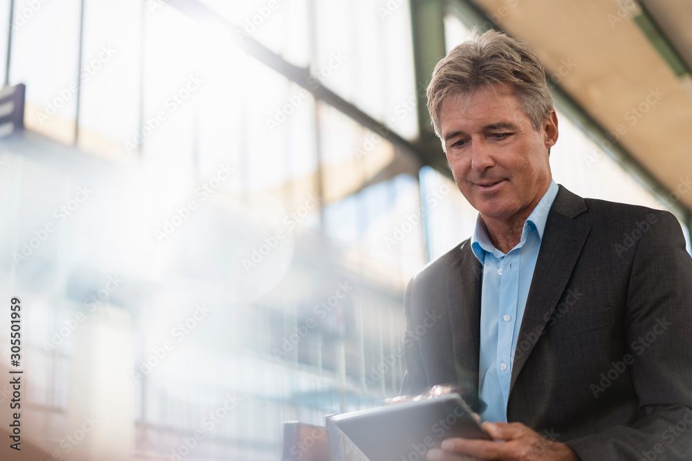 Mature businessman using tablet at station platform Mature businessman using tablet at station platform