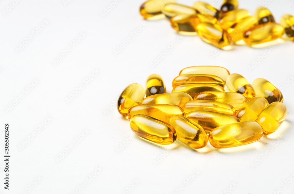 Group of yellow vitamin capsules on white background. Selective focus. Group of yellow vitamin capsules on white background. Selective focus.