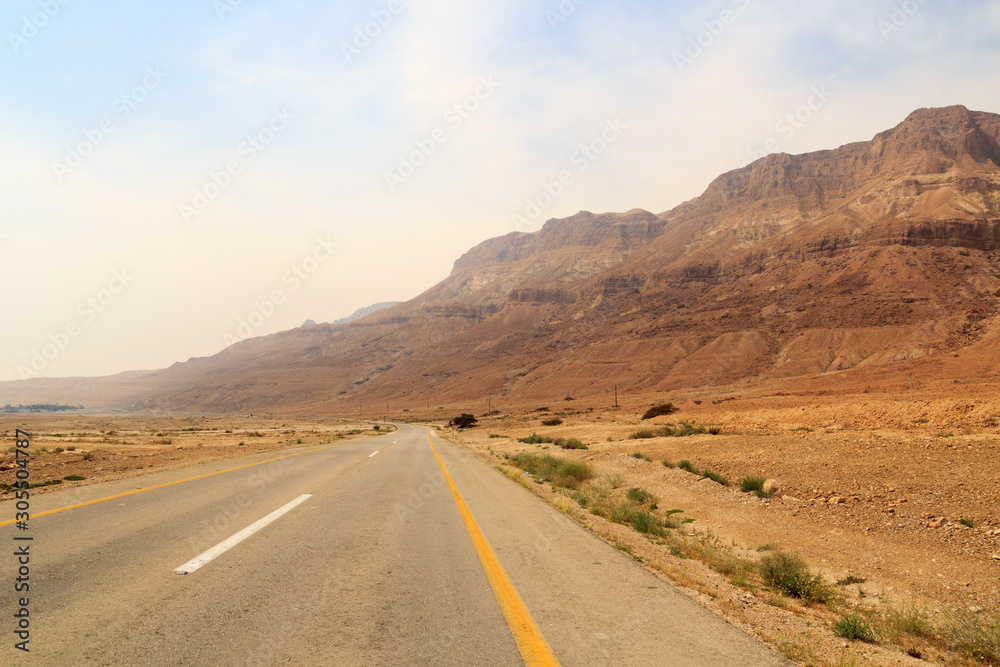 Street highway 90 and Judaean Desert panorama with natural terraces at mountains in West Bank, Israel