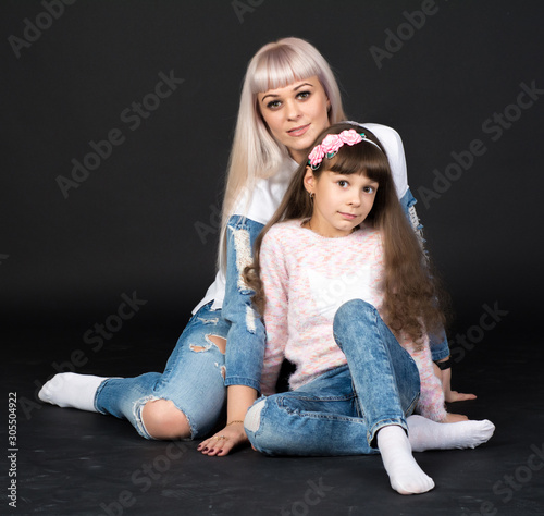 Mother and daughter (woman and girl) are photographed in a photo Studio