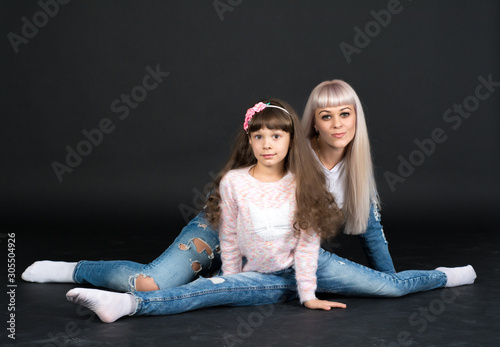 Mother and daughter (woman and girl) are photographed in a photo Studio