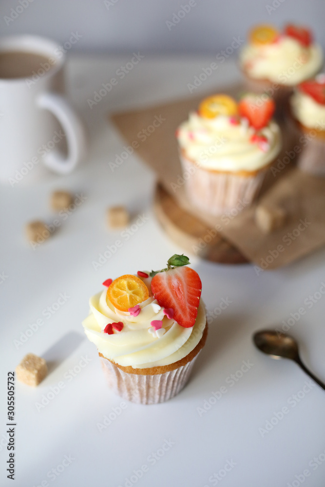 cupcake with cream cheese decorated with strawberries on a white background. cupcake with cream cheese decorated with strawberries on a white background.