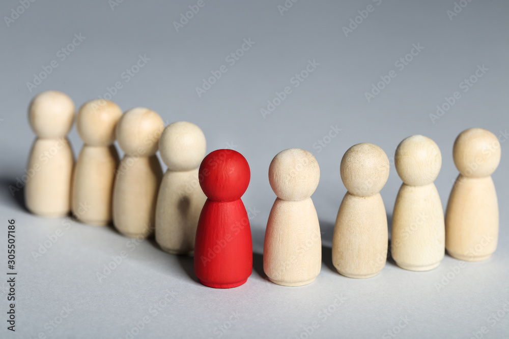 Leader concept. Wooden figures on grey background Leader concept. Wooden figures on grey background
