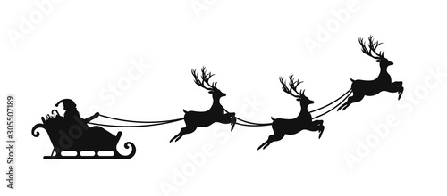 Santa Claus is flying in sleigh with Christmas reindeer. Silhouette of Santa Claus, sleigh with Christmas presents and reindeer photo