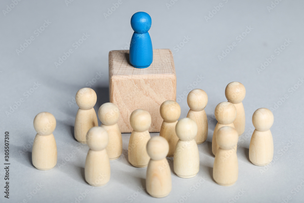 Leader concept. Wooden figures on grey background Leader concept. Wooden figures on grey background