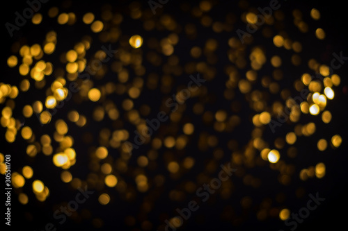 little gold stars on black background Festive holiday background. Celebration concept. Top view  defocused  blured