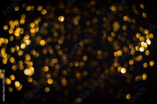 little gold stars on black background Festive holiday background. Celebration concept. Top view, defocused, blured