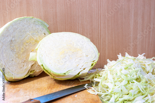 cut along a head of fresh cabbage lies on a table