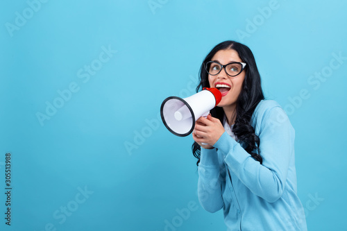 Young woman with a megaphone on a blue background