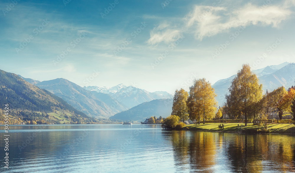 Naklejka premium wonderlust view of highland lake With autumn trees under sunlight