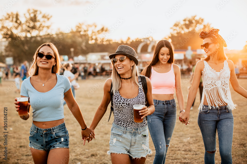 Female friends holding hands and having fun at music festival Female friends holding hands and having fun at music festival