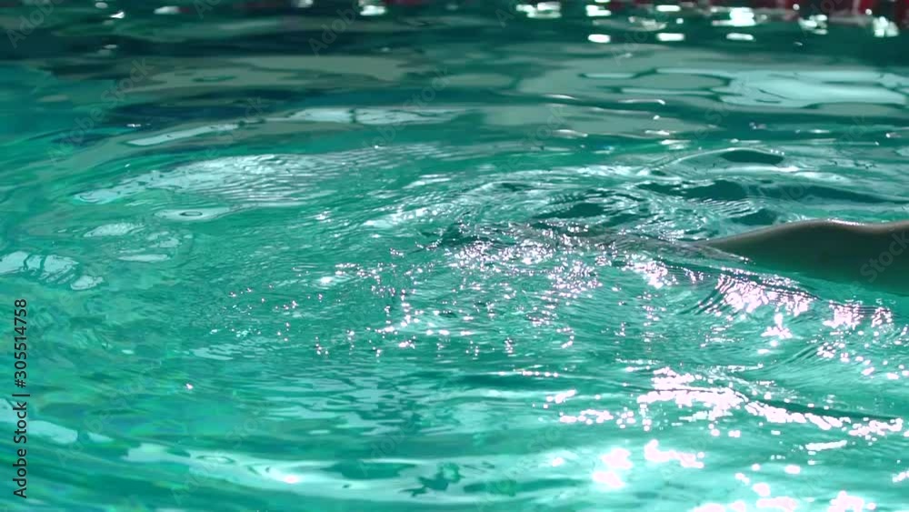 Swimmer hand performing a blow to the water in the pool. Close up