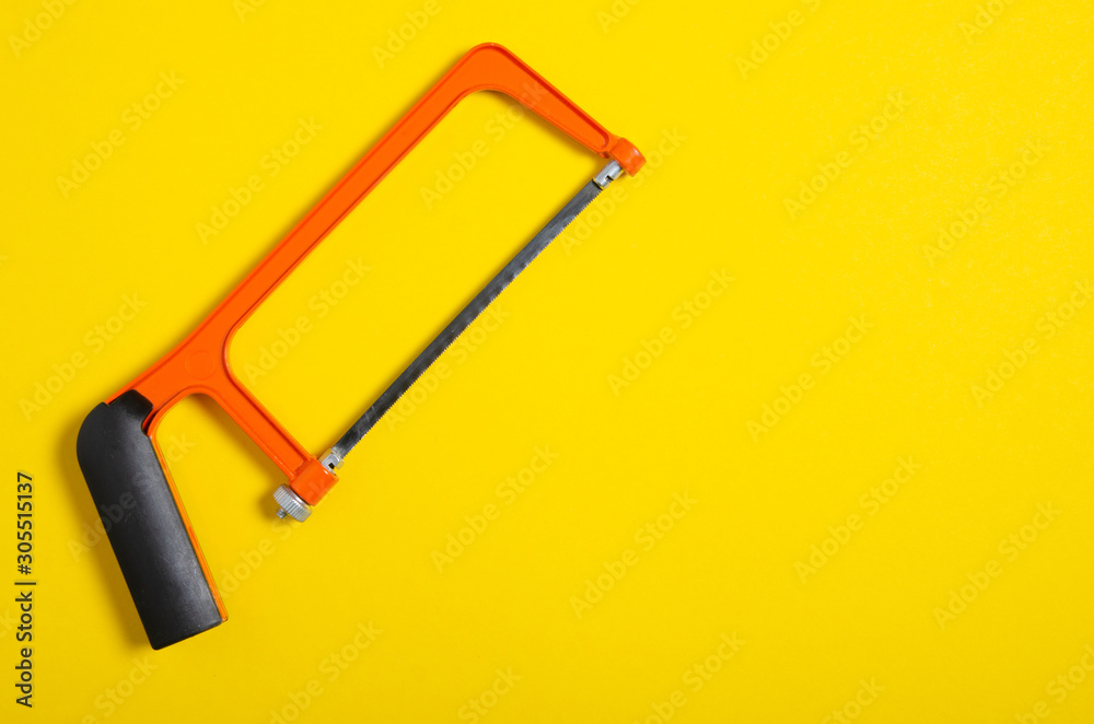 Φωτογραφία hacksaw work hand tool on yellow background, top view, space for text