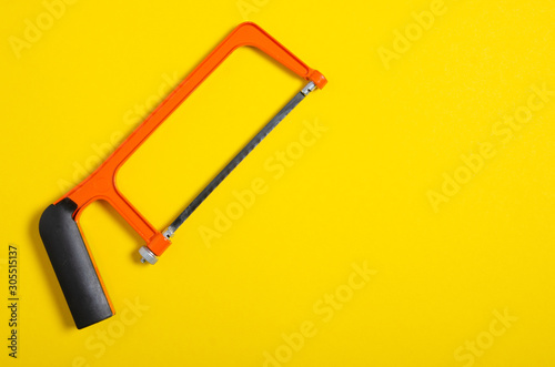 Φωτογραφία hacksaw work hand tool on yellow background, top view, space for text