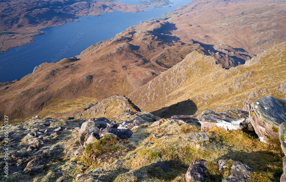Looking down the steep rocky ridges from the summit of Slioch with Loch Maree far below in the Scottish Highlands.